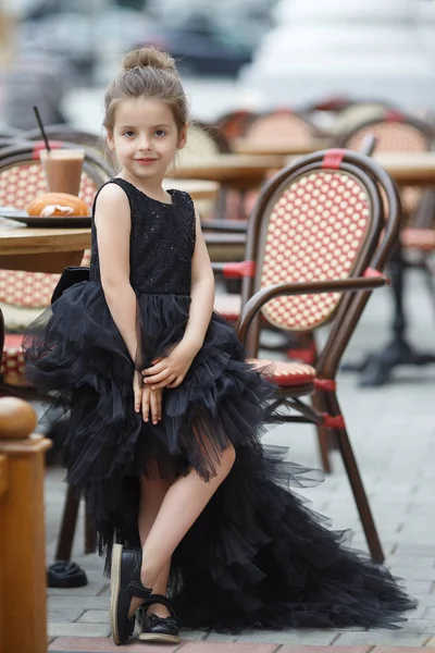 Nettes Kleines Mädchen Einem Schönen Schwarzen Abendkleid Das Einem Tisch — Stockfoto