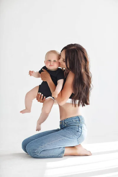 Young Woman Mother Denim Overalls Holds Baby Child Her Arms — Stock Photo, Image