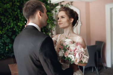 Düğün gününde gelin ve damat yazın şato bölgesinde dışarıda yürüyor. Gelinlik çifti, yeni evli bir kadın ve sevgiyle kucaklaşan bir erkek. İnsanlar mutlu ve gülümsüyor. Gelin, damadın ellerinde. Birbirlerine aşık mutlu çiftler.