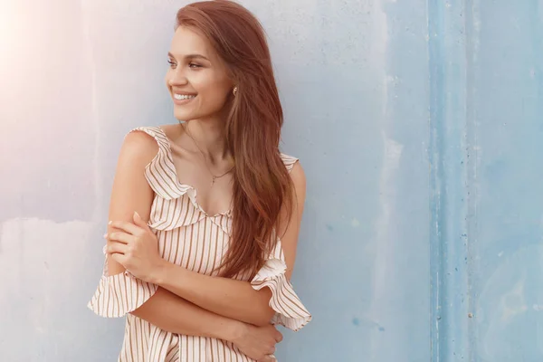 Retrato de uma jovem mulher sorridente perto da parede azul ao ar livre — Fotografia de Stock