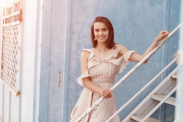 Retrato de una joven sonriente cerca de la pared azul al aire libre — Foto de Stock