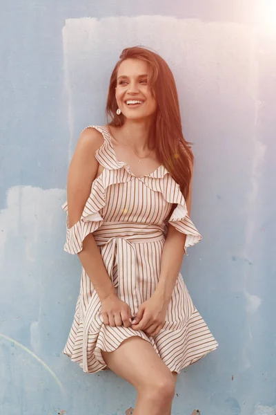 Retrato de uma jovem mulher sorridente perto da parede azul ao ar livre — Fotografia de Stock