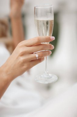 Nikah ve nişan yüzüğü elinde şampanya ile. Bir bardak köpüklü şarapla bir kadın eli. Yüksek kalite fotoğraf