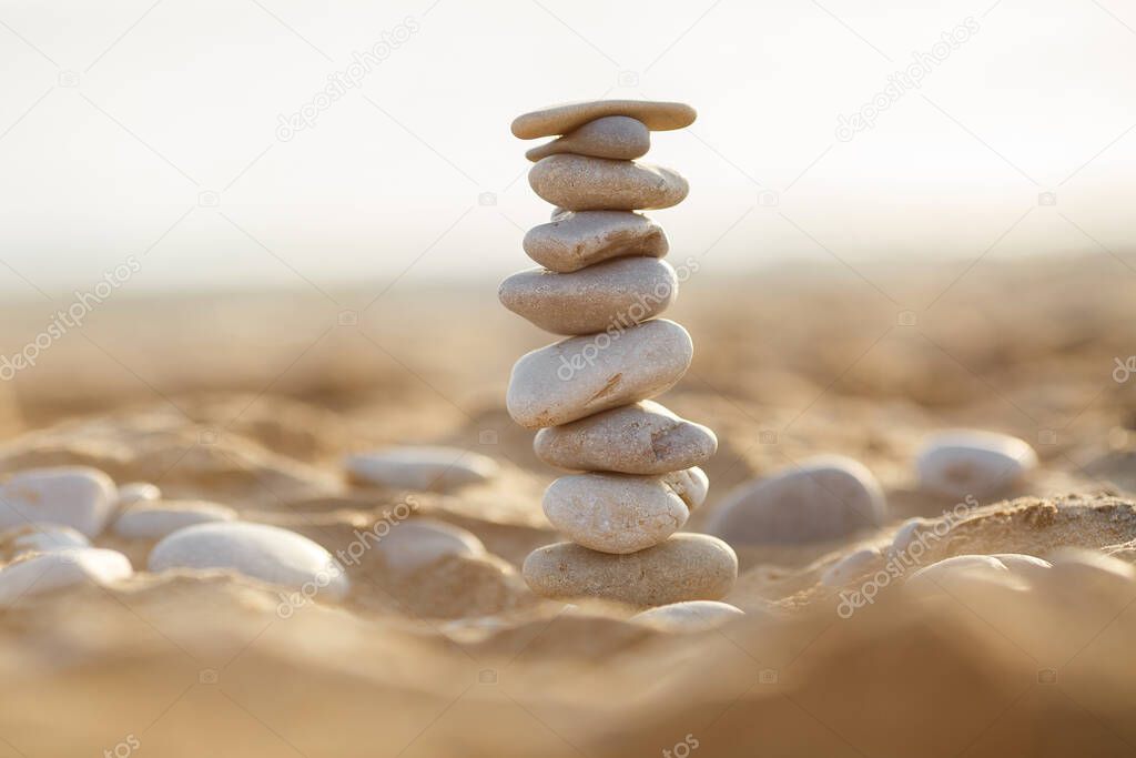 sea stones tower on sand. summer and sunset on sea background. relaxation and meditation on beach. High quality photo