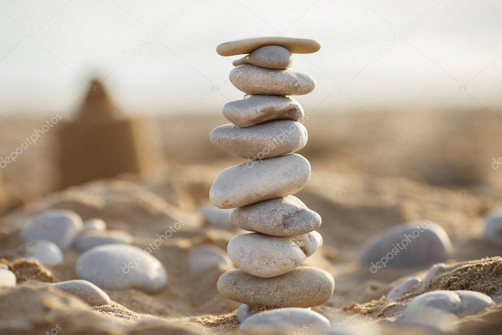 sea stones tower on sand. summer and sunset on sea background. relaxation and meditation on beach. High quality photo