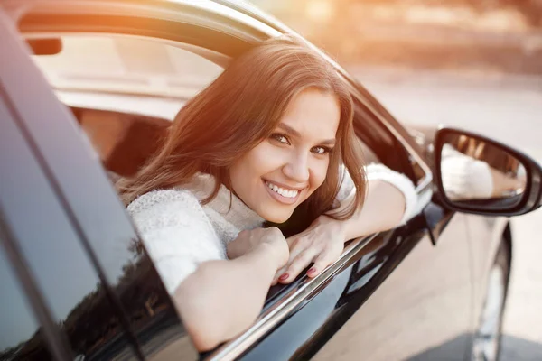 Söt ung kvinna sitter i bilen — Stockfoto