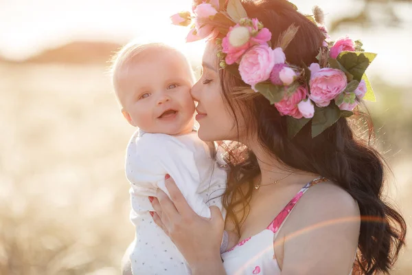 Mother feeding her newborn baby boy from bottle outdoors in the field. artifitial milk feedng — Stock Photo, Image