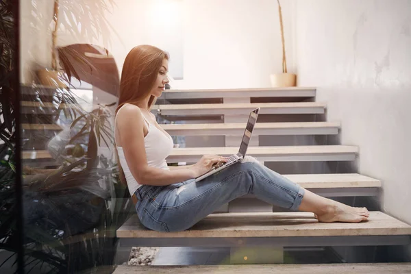 Mulher muito jovem trabalhando em casa com laptop — Fotografia de Stock