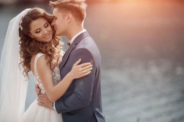 Deniz ve dağ kenarında güzel bir yerde düğün çifti, gelin ve damat sahilde.