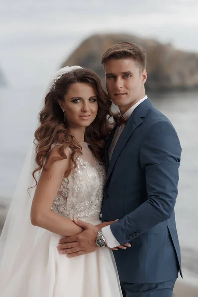 Deniz ve dağ kenarında güzel bir yerde düğün çifti, gelin ve damat sahilde. — Stok fotoğraf