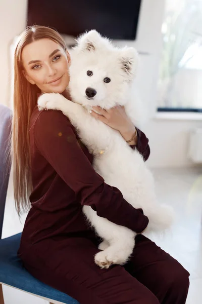 Retrato de una mujer sonriente con perro en casa —  Fotos de Stock