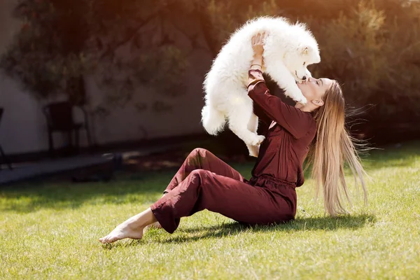 Young smiling woman with dog outdoor near house — Stock Photo, Image