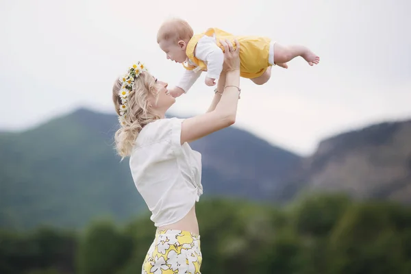 Donna felice con bambino in camomilla. campo bianco fiorito. famiglia nei fiori. madre e figlio — Foto Stock
