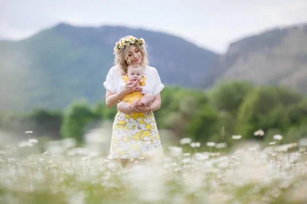 Boldog nő kisfiúval Camomilles-ben. Virágzó fehér mező. Család virágokkal. Anya és fia. — Stock Fotó