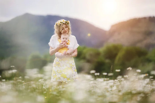Šťastná žena s malým chlapečkem v Camomille. rozkvetlé bílé pole. rodina v květinách. matka a syn — Stock fotografie
