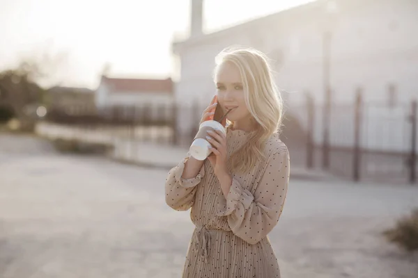 Jeune jolie femme avec café parlant téléphone en plein air — Photo