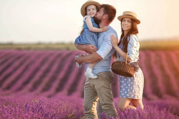 Gelukkige familie in Laveder Field. moeder, vader en kind bij zonsondergang licht in bloeiende lavendel — Stockfoto