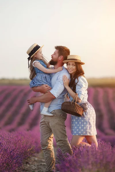 Familia feliz en el campo de laveder. madre, padre e hijo en la luz del atardecer en flor lavanda —  Fotos de Stock