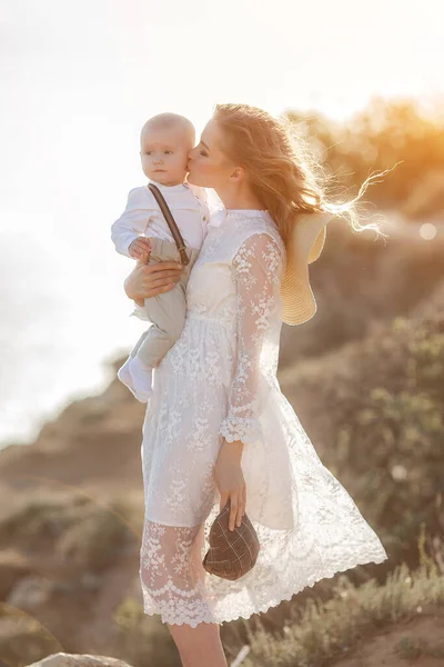 Hermosa mujer bonita con bebé niño al atardecer al aire libre. madre con hijo — Foto de Stock