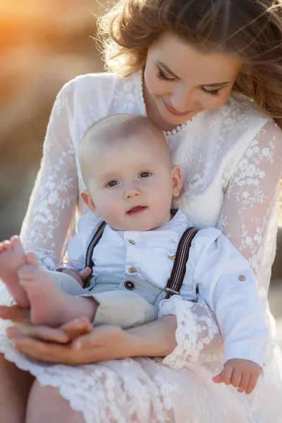 Gyönyörű csinos nő kisfiúval a szabadban, naplementekor. anya a fiával — Stock Fotó