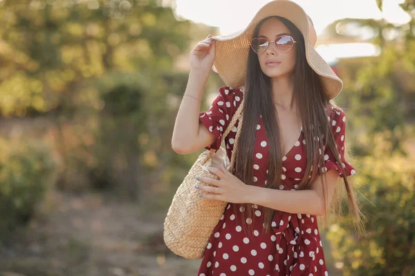 Módní mladá žena venku s kloboukem, taškou a slunečními brýlemi — Stock fotografie