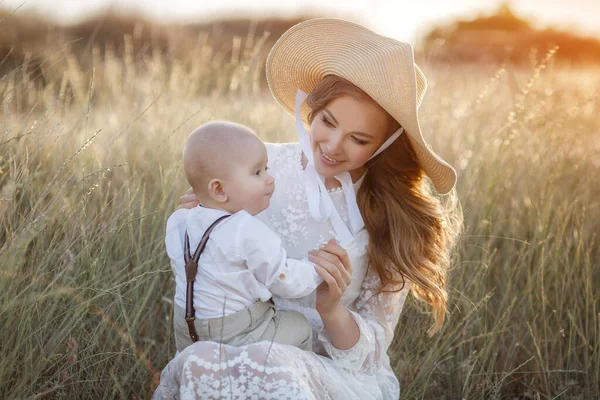 Hermosa mujer bonita con bebé niño al atardecer al aire libre. madre con hijo —  Fotos de Stock