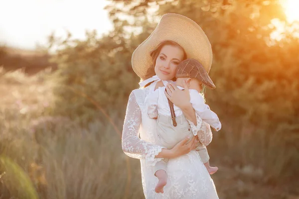 Schöne hübsche Frau mit Baby Boy bei Sonnenuntergang im Freien. Mutter mit Sohn — Stockfoto