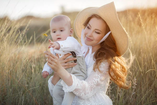 Gyönyörű csinos nő kisfiúval a szabadban, naplementekor. anya a fiával — Stock Fotó