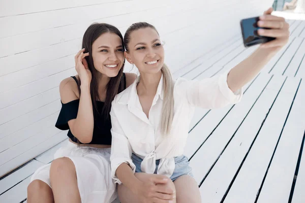 Dois amigos mulheres ao ar livre fazendo selfie sorrindo — Fotografia de Stock