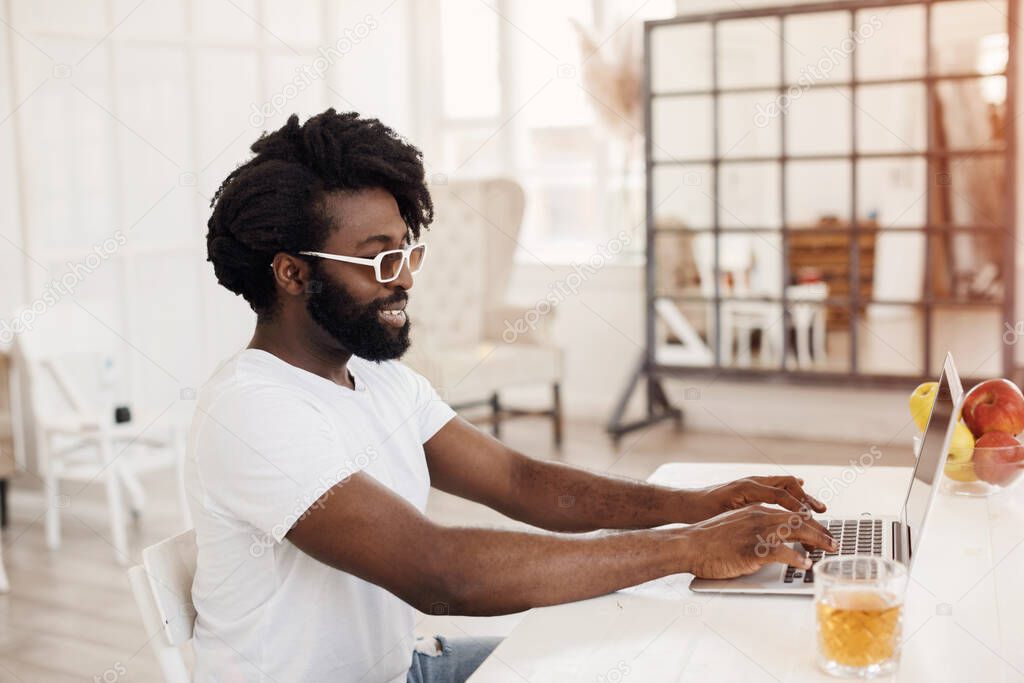 Young black man working at home with laptop