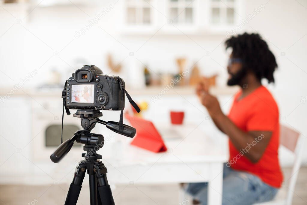 Handsome man recording video business course at home, focus on camera