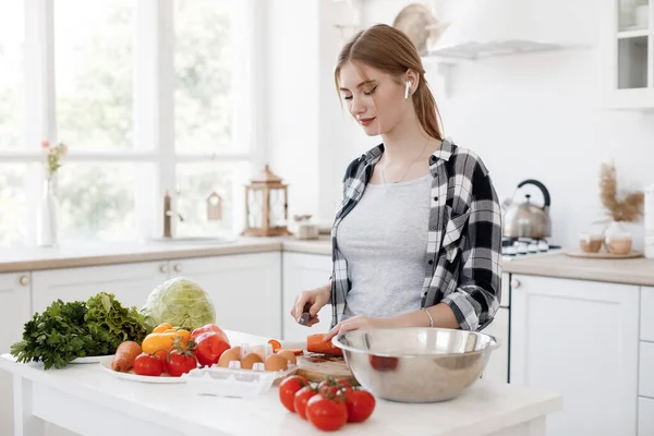 Mujer joven cocinando en casa en la cocina con tableta —  Fotos de Stock