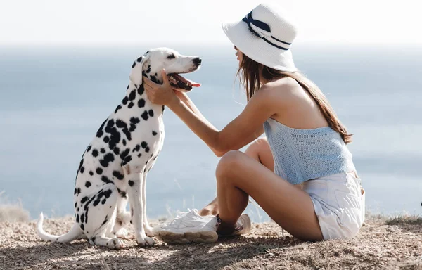 Szczęśliwa kobieta z psem dalmatyńczykiem w delikatnych kolorach zachodu słońca — Zdjęcie stockowe