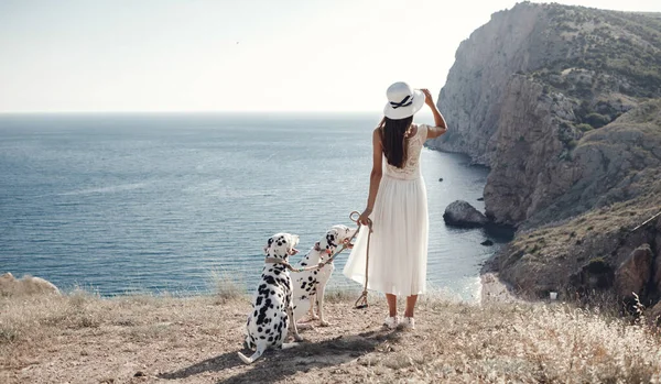 一个带着狗的女人女孩和她的朋友的狗在蓝色的大海背景上 — 图库照片