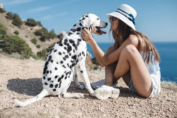 Mujer feliz con un perro dálmata en suaves colores atardecer — Foto de Stock