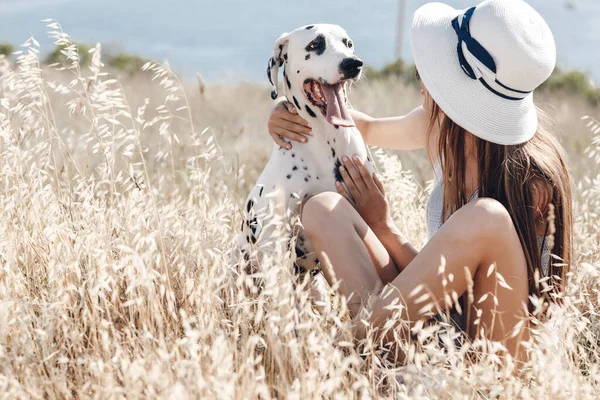 Kobieta z psem dalmatyńczykiem w polu latem — Zdjęcie stockowe