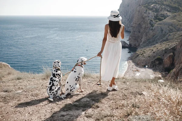 Kvinna med en hund dalmatier. Flicka och hennes vän hund på blå havet bakgrund — Stockfoto