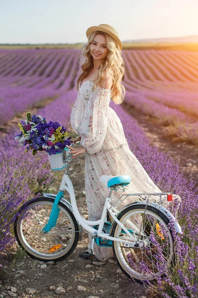 Bonita mujer rubia huyendo en el campo de lavanda. mujer en vestido largo divirtiéndose en flores de lavanda — Foto de Stock