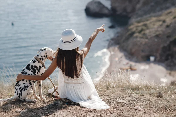 Mujer con un perro dálmata. Chica y su amigo perro en el fondo azul del mar — Foto de Stock