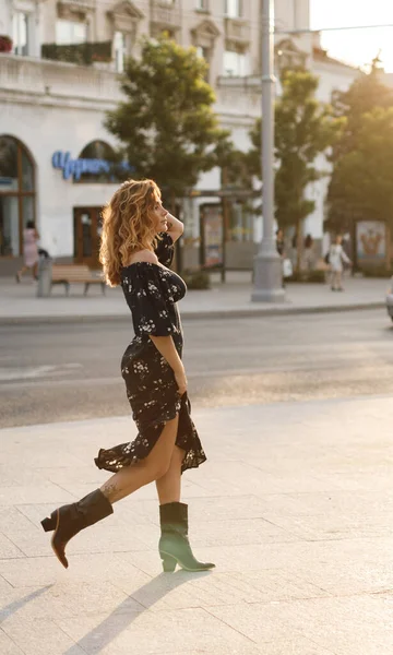 Feliz joven mujer caminando en la calle de la ciudad en la puesta del sol luz cálida. Sonriente chica emocional al aire libre en verano —  Fotos de Stock