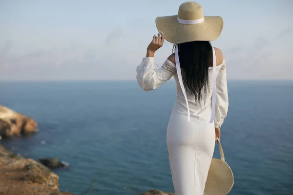 Backside mode femme en robe et chapeau près de la mer océan — Photo