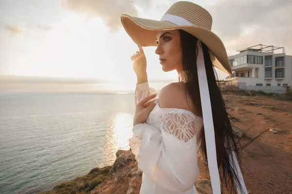 Mode kvinna i klänning och hatt nära havet — Stockfoto