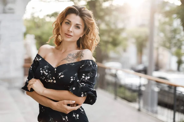 Felice giovane donna a piedi in strada della città al tramonto luce calda. Sorridente ragazza emotiva all'aperto in abito estivo — Foto Stock