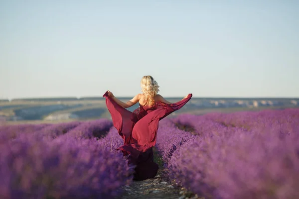 Happy young blonde woman in dress having fun in lavender blooming field in summer day — Stock Photo, Image