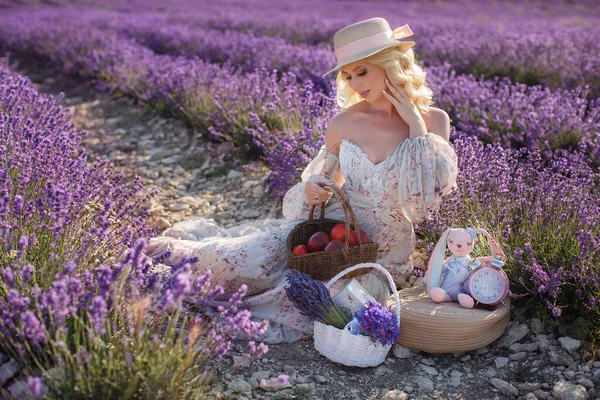 Heureuse jeune femme blonde en robe s'amuser dans le champ de fleurs de lavande en journée d'été — Photo
