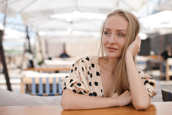 Close up portrait of a beautiful blond woman outdoor at summer terrace cafe 