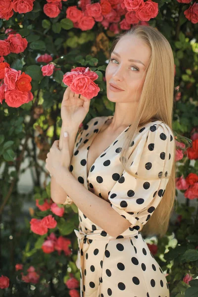 Portrait of a young beautiful woman in dress in roses flowers outdoor — Stock Photo, Image