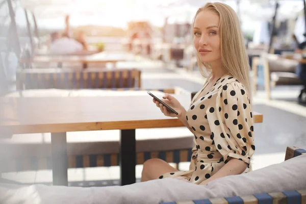 Portrait of a young woman outdoor in cafe with mobile phone — Stock Photo, Image