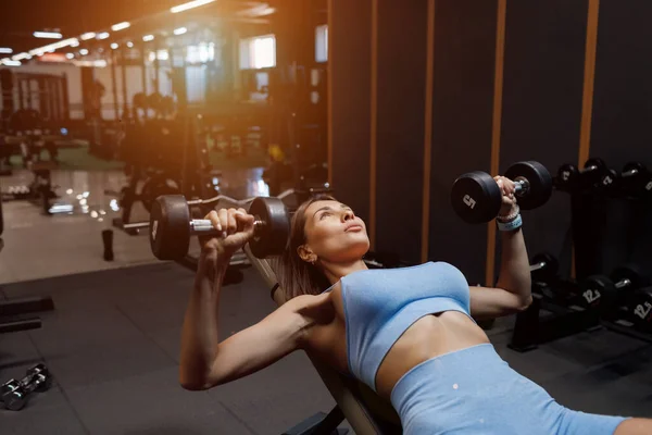 สาวนักกีฬาที่สวยงามในชุดกีฬายกน้ําหนัก แนวคิดของโรงยิมกีฬา — ภาพถ่ายสต็อก