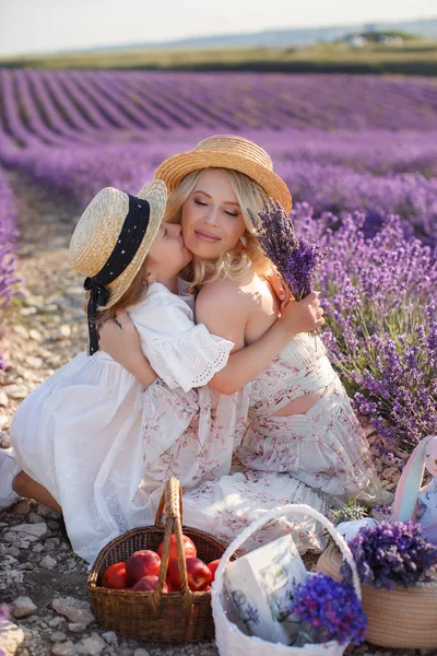 Vrouw met dochter in witte jurken hebben plezier in lavendelveld in de zomer. familieportretten — Stockfoto